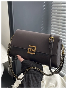 Détail d'un sac bandoulière marron rétro avec fermoir doré et texture plissée élégante