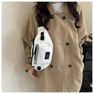 Detail view of white nylon crossbody bag with reflective strap and plastic buckle closure