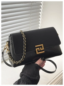 Détail du sac bandoulière vintage noir avec fermoir doré et texture de cuir plissé
