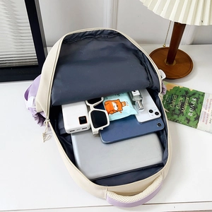 Versatile student backpack in beige and purple showing spacious interior with laptop storage