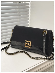 Détail du sac bandoulière noir vintage avec fermoir doré et bandoulière chaîne