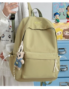 Detail of light green nylon backpack with cute bear pendant and XNFEIDA logo embroidery