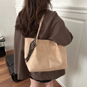 Sac fourre-tout en daim marron clair pour femme avec pompon à franges porté à l'épaule