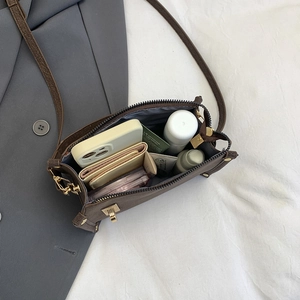 Brown textured crossbody mini bag showing interior capacity with phone and wallet