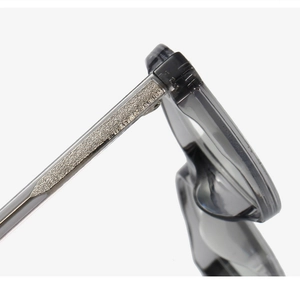 Detail of transparent grey glasses arm featuring a textured metal core and sturdy hinge