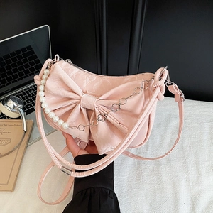 Borsa rosa con fiocco, catena di perle e tracolla in un design dolce e femminile