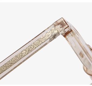 Detail view of gold-engraved patterns inside high-quality transparent champagne eyeglass temples
