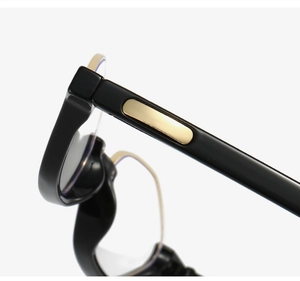 Close-up of retro round glasses frame with gold oval hinge detail and black finish