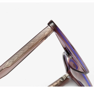 Macro detail of brown cat eye sunglasses frame showing metallic feather pattern core