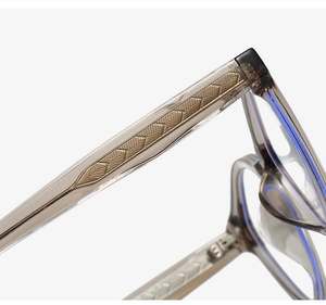 Détail macro de la branche de lunettes TR90 avec noyau doré gravé et verre anti-lumière bleue