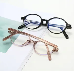 Close-up of retro oval acetate glasses with metal arrow pins and blue light lenses