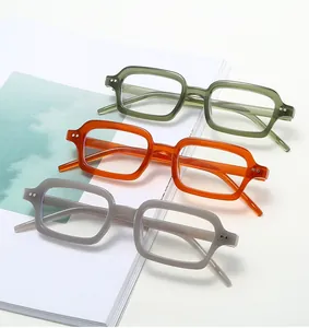 Detailed view of rectangular chunky eyewear frames in olive green, bright orange and light grey