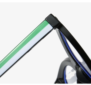 Macro detail of cat-eye eyewear showing the black temple with green and white color blocking