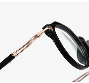 Detail of black TR90 oval glasses frame with rose gold metal hollow temple hinge