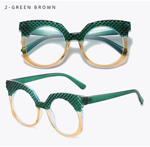 Dettaglio di occhiali cat-eye oversize con texture a rombi verdi e sfumatura ambra