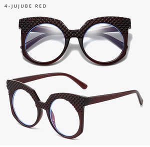 Dettaglio occhiali grandi rosso giuggiola con texture trapuntata chic e forma cat-eye