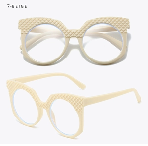 Dettaglio degli occhiali beige oversize con trama a rombi sulla montatura e aste