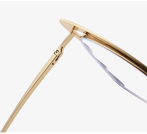 Macro view of gold metal eyewear frame featuring stylish cat-ear shaped rim details