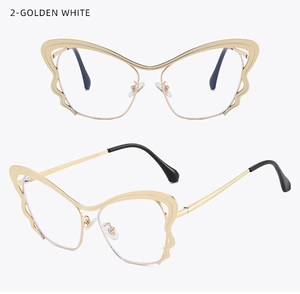 Detail of golden butterfly shaped metal eyeglass frames with wavy wings and black tips