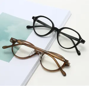 Detail of retro oval frames in black and tea brown with metal rivets on minimalist background
