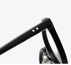 Close-up of gloss black oval frame temples with silver rivets and metal hinges