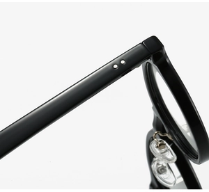 Detail of TR90 glasses frame showing black hinge with silver rivets and silicone nose pads