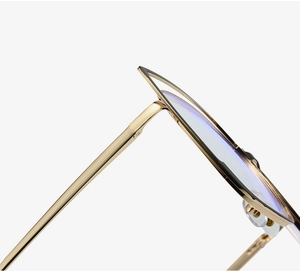 Detail of gold metal cat-eye frames with black accents and blue light blocking lenses