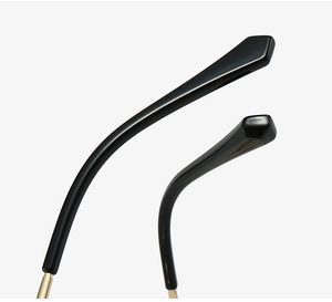 Detail of glossy black acetate temple tips and gold metal hinge on cat eye glasses
