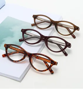 Detailed shot of retro oval glasses frames in tortoiseshell and amber with metal rivets