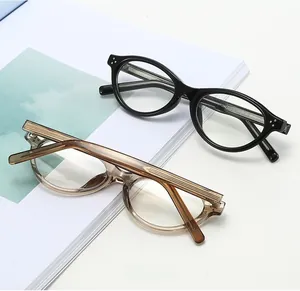 Detail of retro oval optical frames in black and amber with metal rivet accents