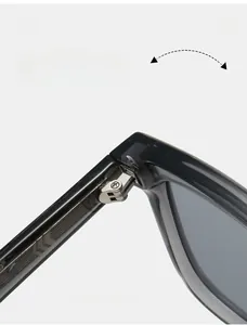 Détail macro de la charnière en métal argenté robuste sur des lunettes de soleil noires
