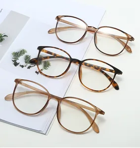 Three retro lightweight TR90 optical frames in brown and tortoise on magazine background