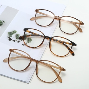 Three pairs of lightweight retro TR blue light glasses in various colors on a magazine