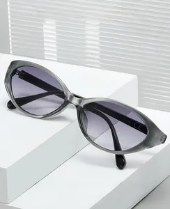 Close-up of cat-eye sunglasses with translucent grey frames and purple gradient lenses