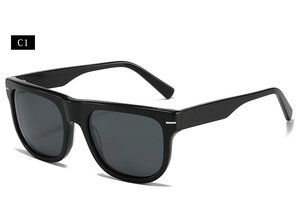 Detail view of square black sunglasses with silver rivet accents and dark lenses