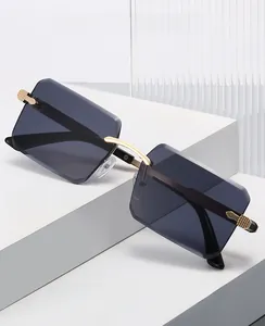 Close-up of frameless square sunglasses with gradient blue lenses and gold metal bridge