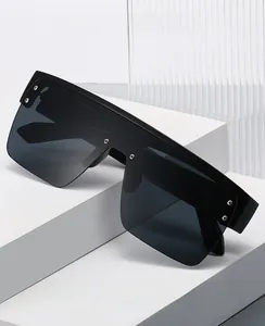 Detail of oversized matte black sunglasses with silver studs on dark shield lenses