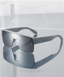 Detailed close-up of grey shield sunglasses with matte frames and metal rivet accents