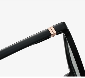 Macro view of glossy black glasses frame with premium rose gold metal hinge details