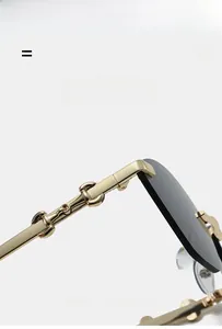 Detail of gold metal cat-eye sunglasses with horsebit hinge and dark gray lenses