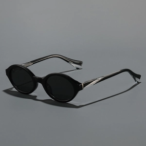 Vintage oval black sunglasses with translucent textured temples on a gray background