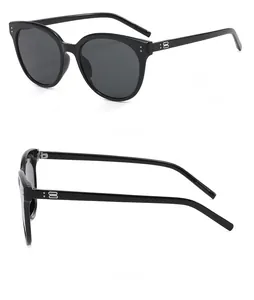 Detail view of black cat-eye sunglasses featuring metallic double B logo on the temple