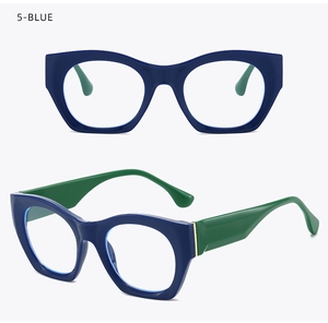 Detail of cat-eye glasses with navy blue frame, green temples and gold hinge accents