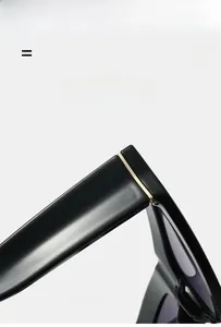 Gros plan des lunettes de soleil triangle noires avec détails décoratifs en métal doré