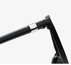 Detailed close-up of glossy black TR90 eyewear temple with silver heart-shaped metal inlay