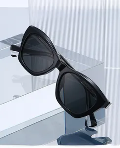 Close-up of black cat-eye sunglasses on a glass staircase with sleek vertical stripes
