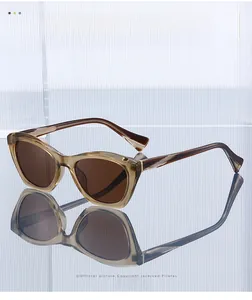 Detailed view of cat-eye sunglasses with amber frame and brown lenses on reflective glass
