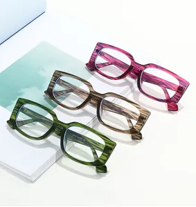 Detailed view of striped sunglasses in green, brown and pink on a white magazine