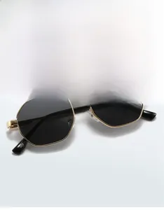 Detail of gold polygonal metal sunglasses with dark lenses and model 9628 on the temple