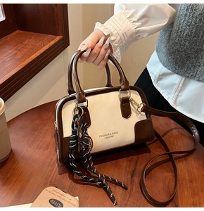 Detailed shot of retro cream and brown bicolor Boston bag with adjustable shoulder strap